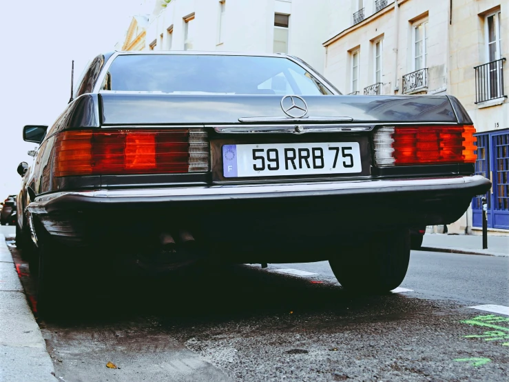 a vintage mercedes benz is parked in front of a building