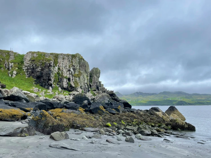 a small island sits on the shore under a cloudy sky