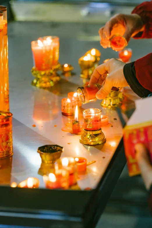 people lighting candles and standing around a table