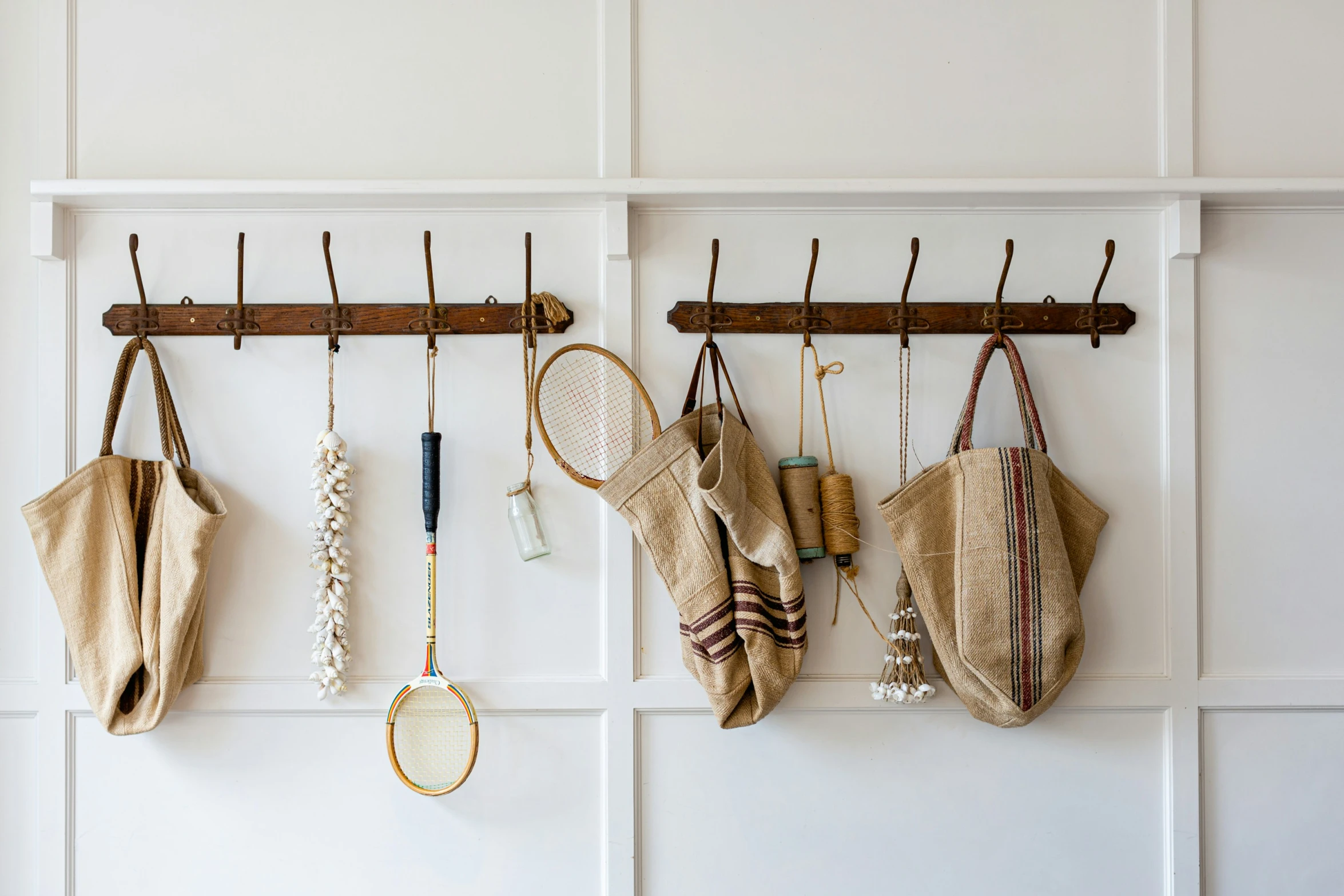 a wall filled with hanging items next to a pair of pants