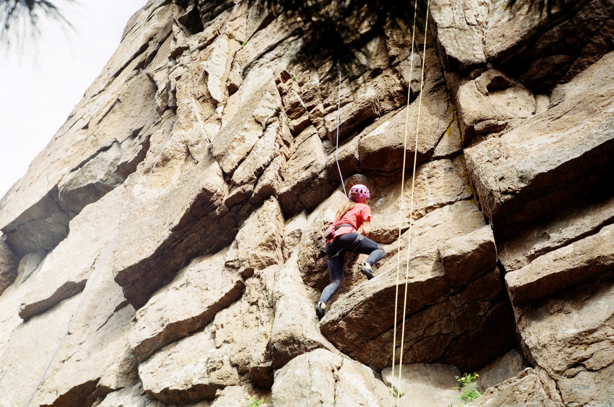 a person climbing up a rocky mountain on a rope