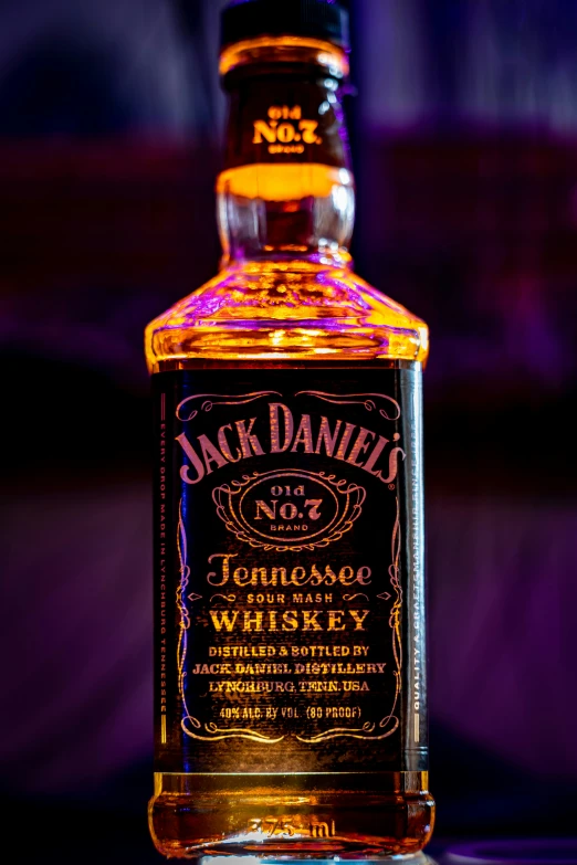 a bottle of jack daniels is illuminated at night