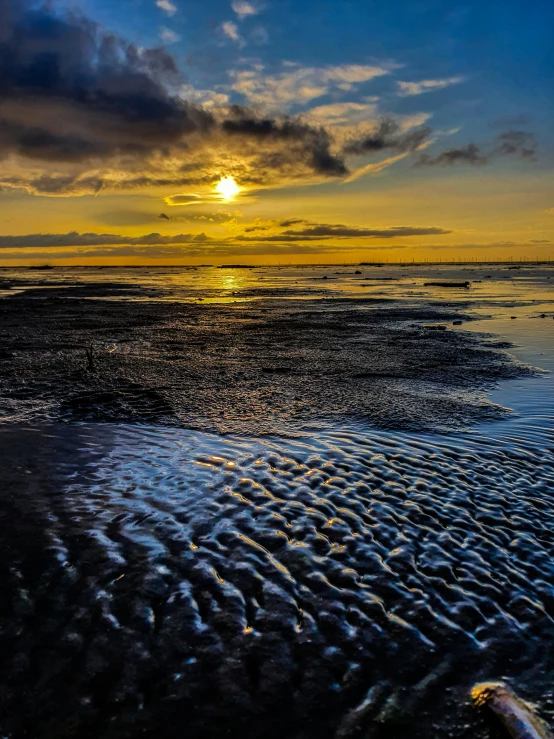 the sun sets over the ocean in an image