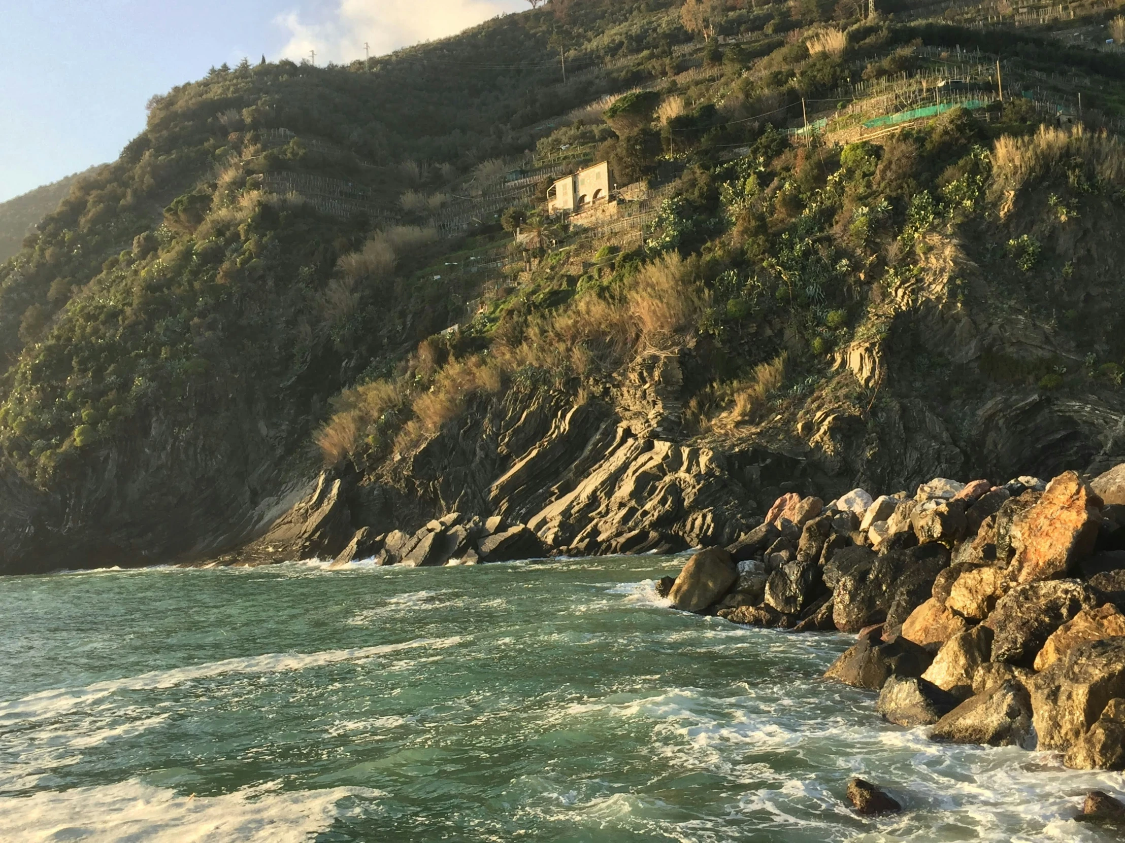 a boat is out on the water by the rocky coast