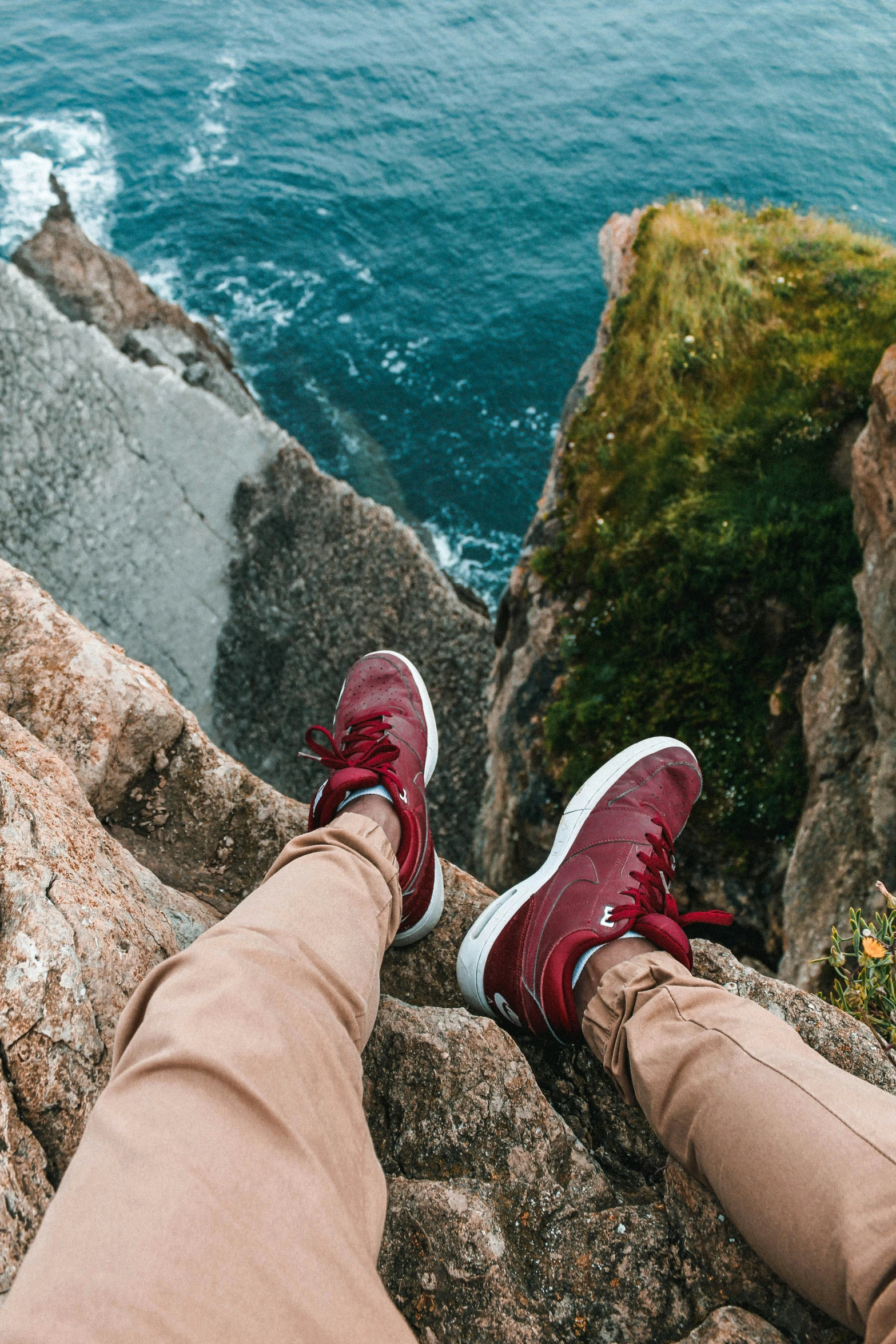 someone wearing red shoes on top of a mountain