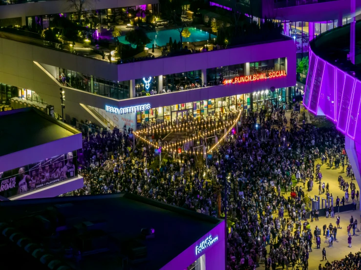 an aerial view of several people standing in front of a building at night