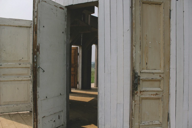 open doors of an abandoned building in front of a window