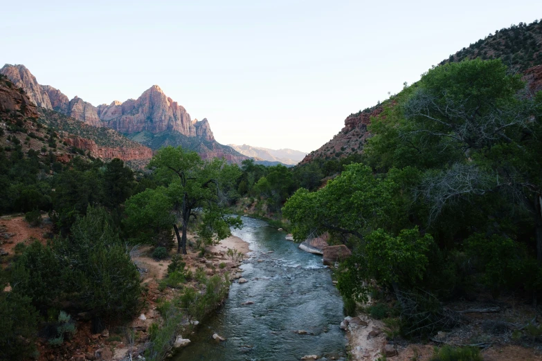 a river flows into a valley with a mountainous area in the distance