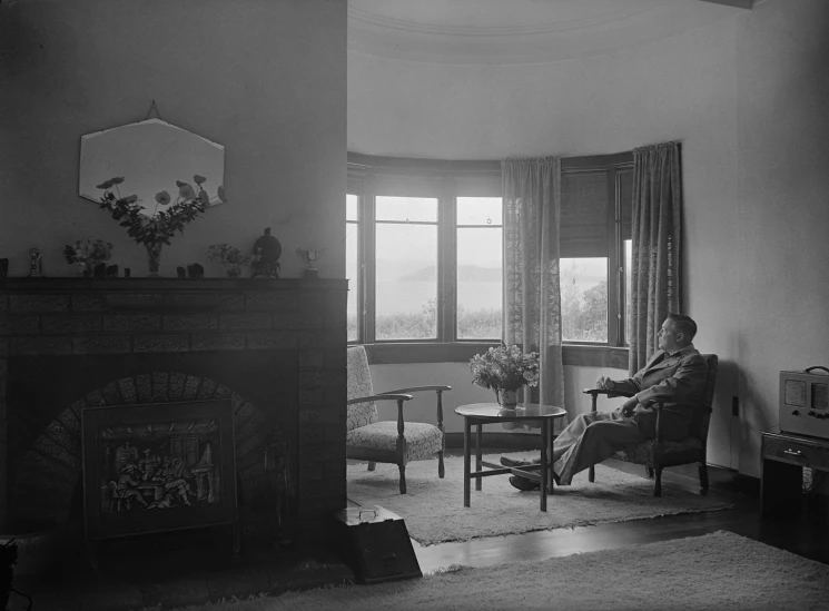 an old po of a person in a living room by a fireplace