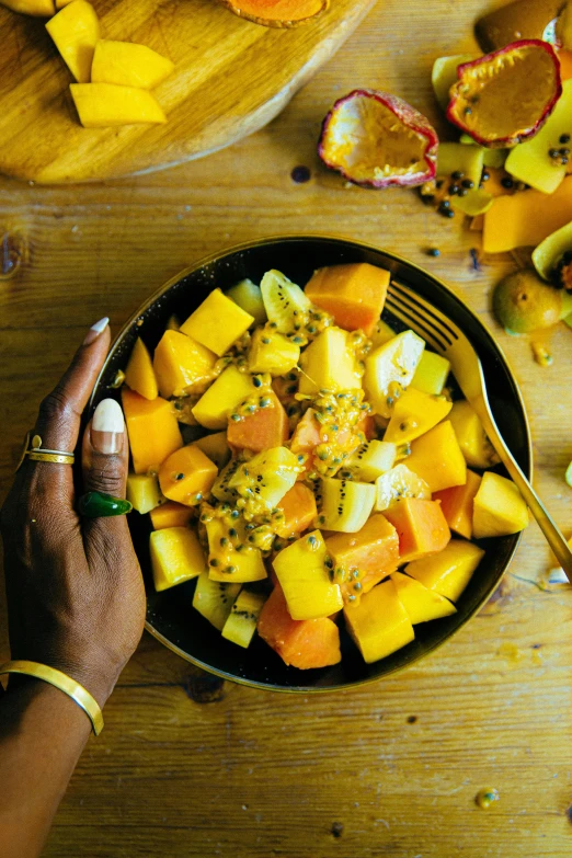 a person with a bowl of fruit and some silverware