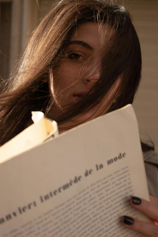 woman leaning on wall while reading a book