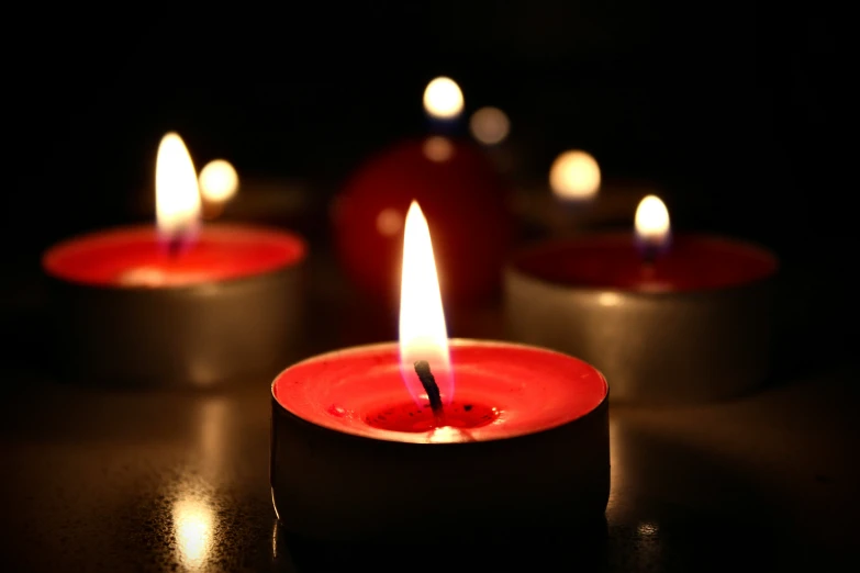 a group of small candles glowing in the dark