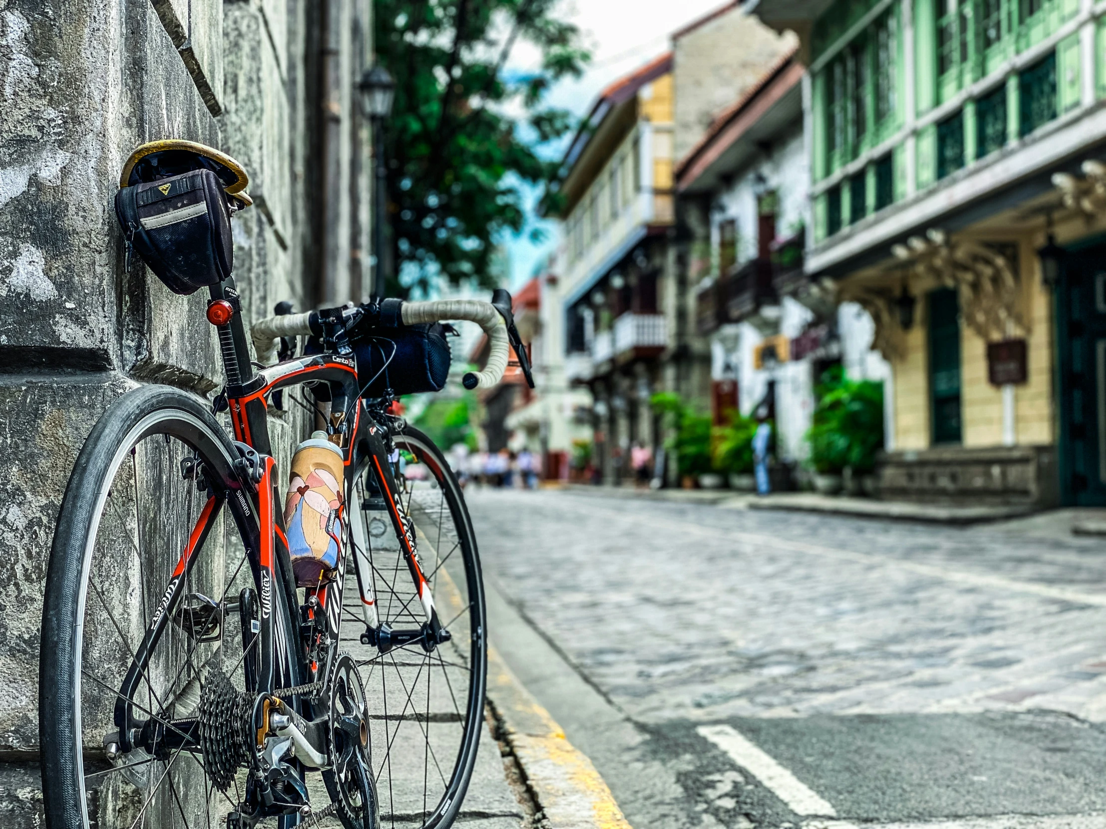 the bike is locked to the wall on the street