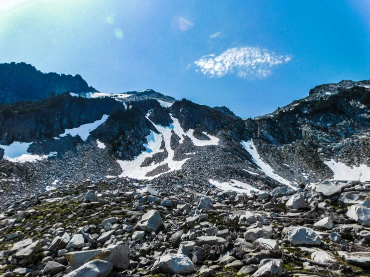 a mountain in the distance with snow and rocks below