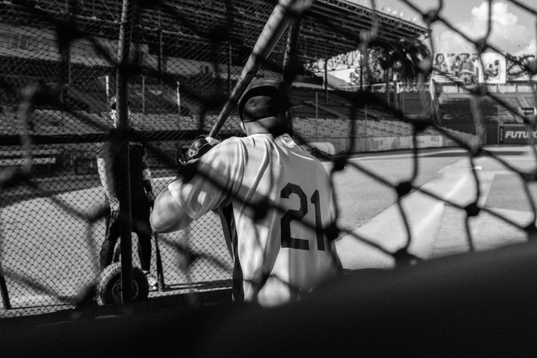 a baseball player holding a bat at the batting cage