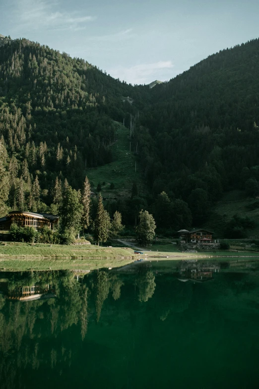 the view of a house and mountains from across the water