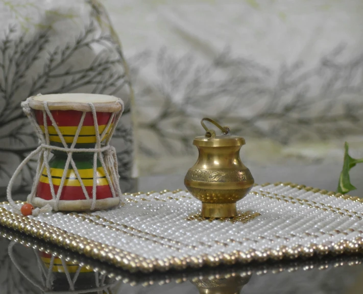 a musical instrument sits on a table next to a small gold cup