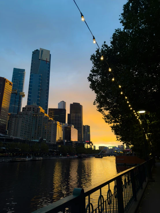 the river is running under the lights and in front of the city