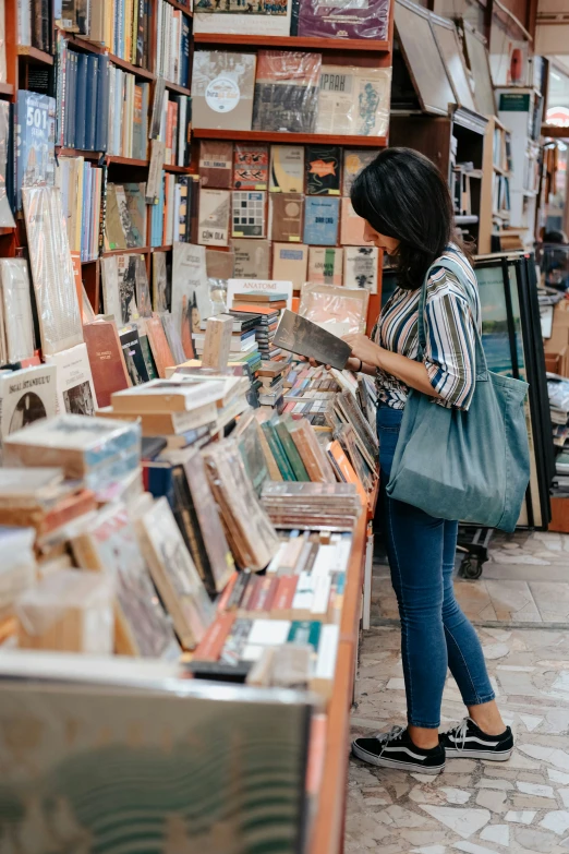a woman looking at a book in a bookstore