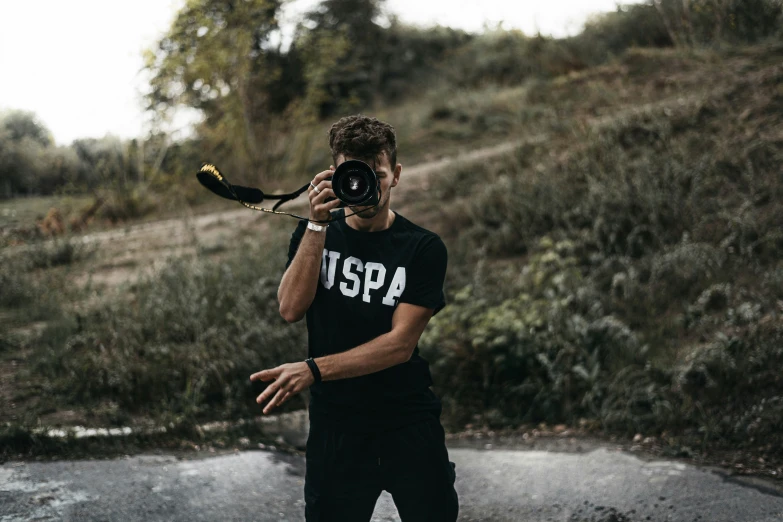 a man taking pictures of the terrain and hills in the background