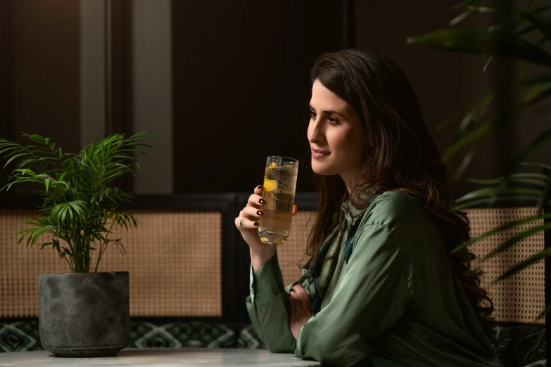 a beautiful woman holding up a drink in front of her