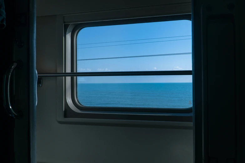 a window is open to the ocean as seen from inside a boat