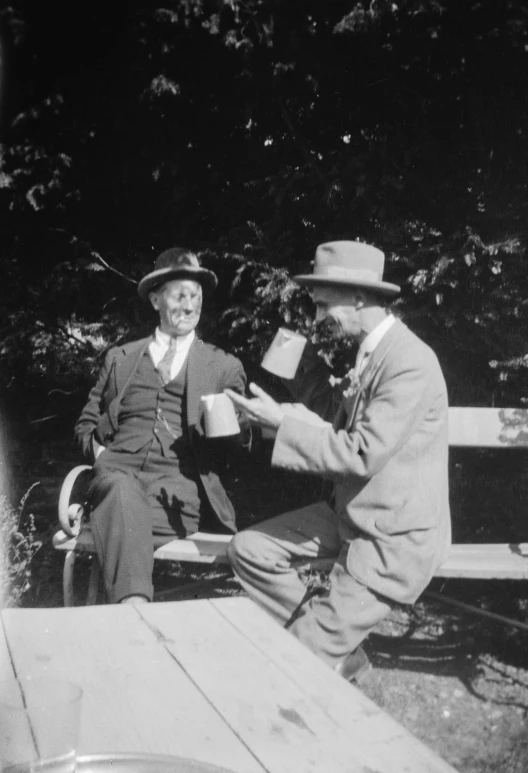 an old po of two men sitting on a bench