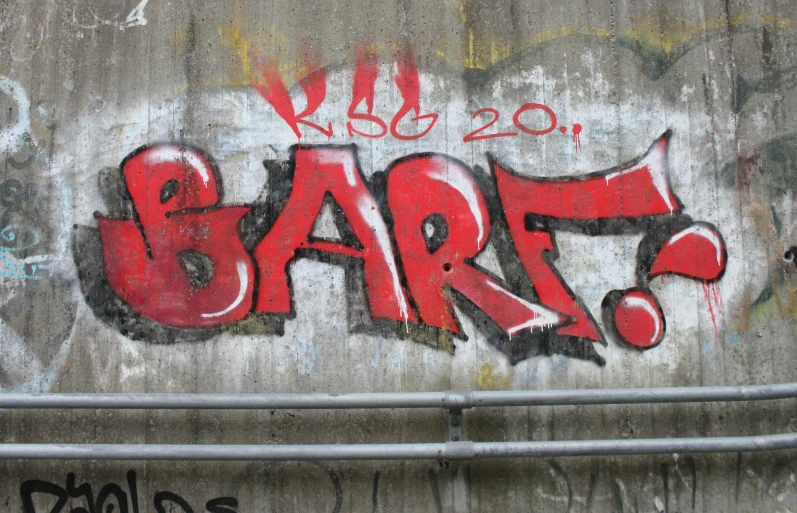 a concrete wall with a red graffiti writing on it