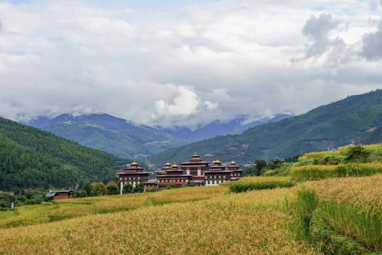 landscape po looking at the buildings in a valley with mountains and clouds