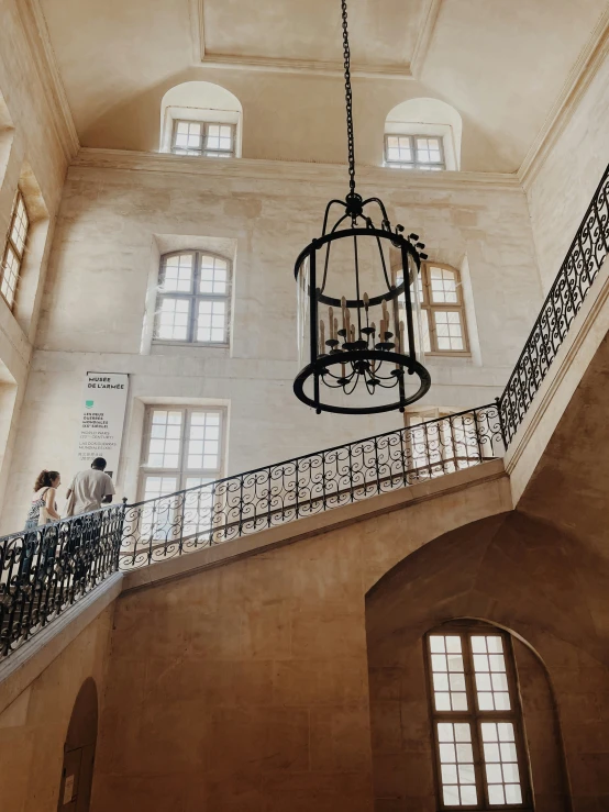 a balcony area with a chandelier and three windows