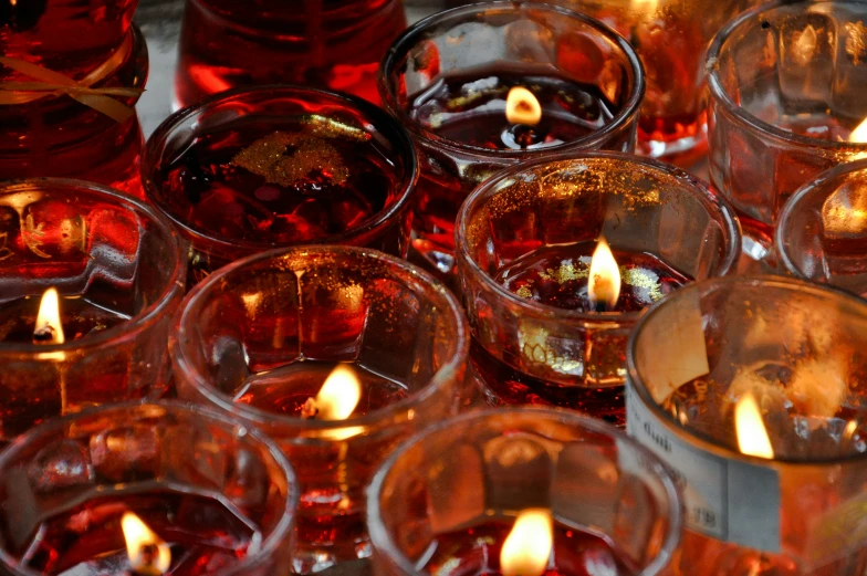 lit candles in glasses in the center of a group