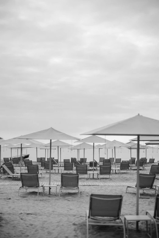chairs and umbrellas are arranged on the sandy beach