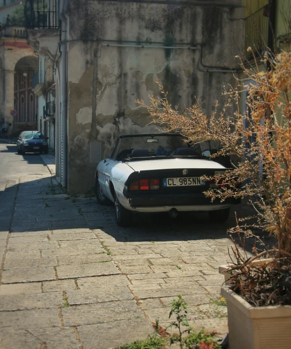 an old car parked near a building on a city street