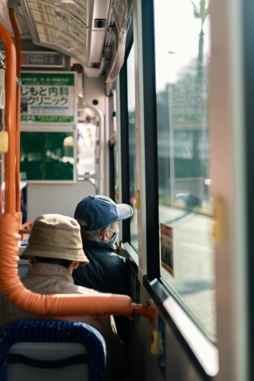 two people sit on the subway looking out the window