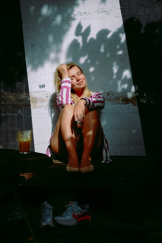 there is a woman sitting on a ledge next to a wall