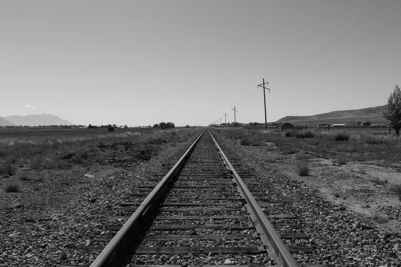 railroad track running through rural landscape with telephone poles