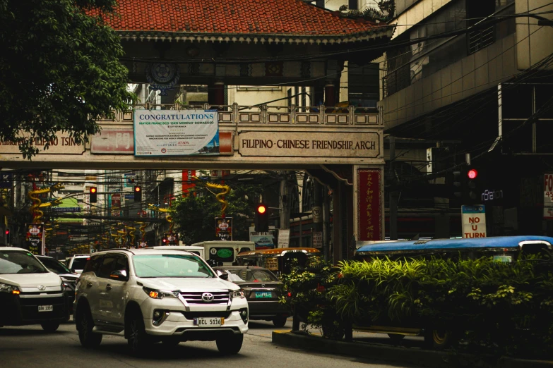 cars traveling down a street under an archway