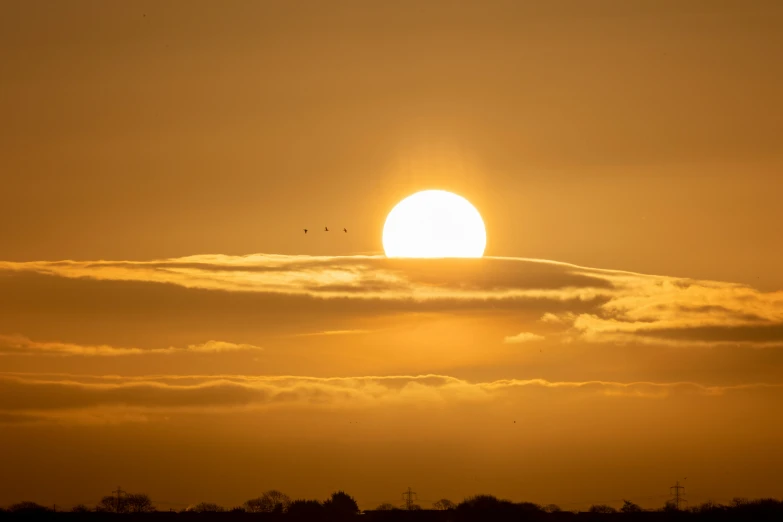 a boat sails in the water and a bright sun