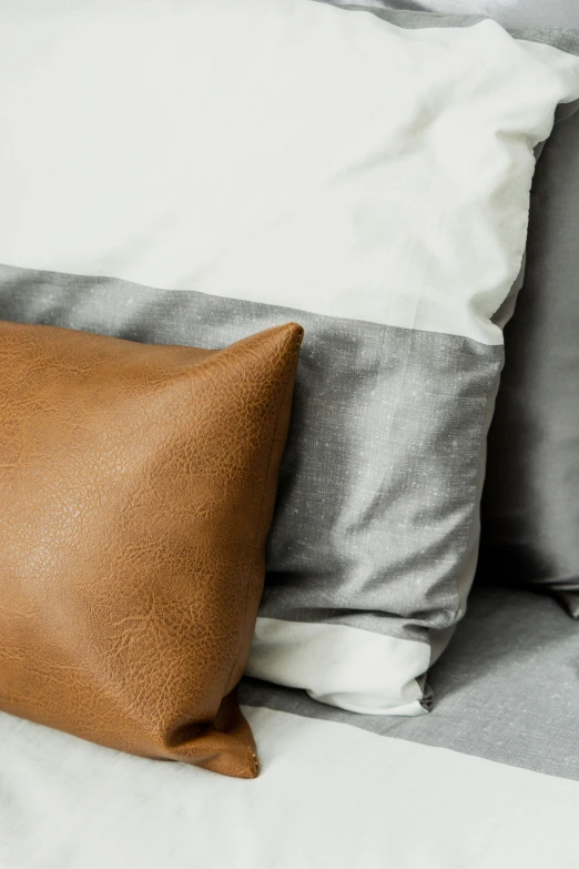 a pillow with a light brown leather pillow case