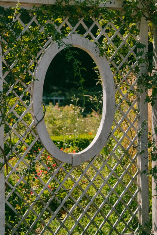 there is an outdoor garden with a round mirror