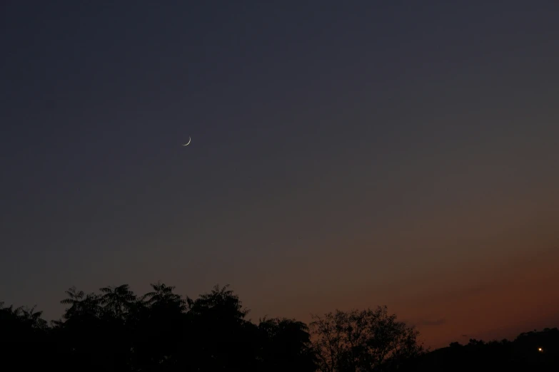 the airplane is flying in a clear sky at sunset