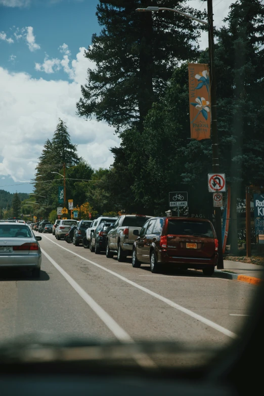 a long line of cars at an intersection with the stop light and street sign