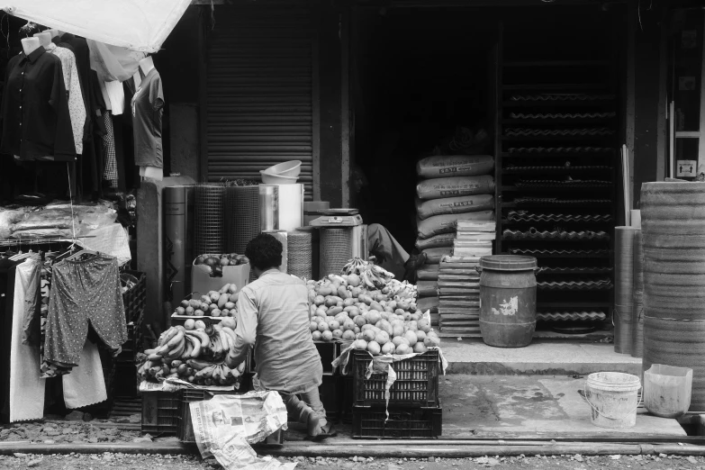a black and white po of a child shopping for produce at an outdoor market