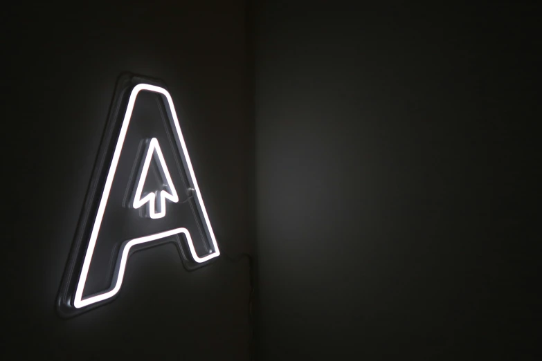 a white light up arrow sign in the middle of a room