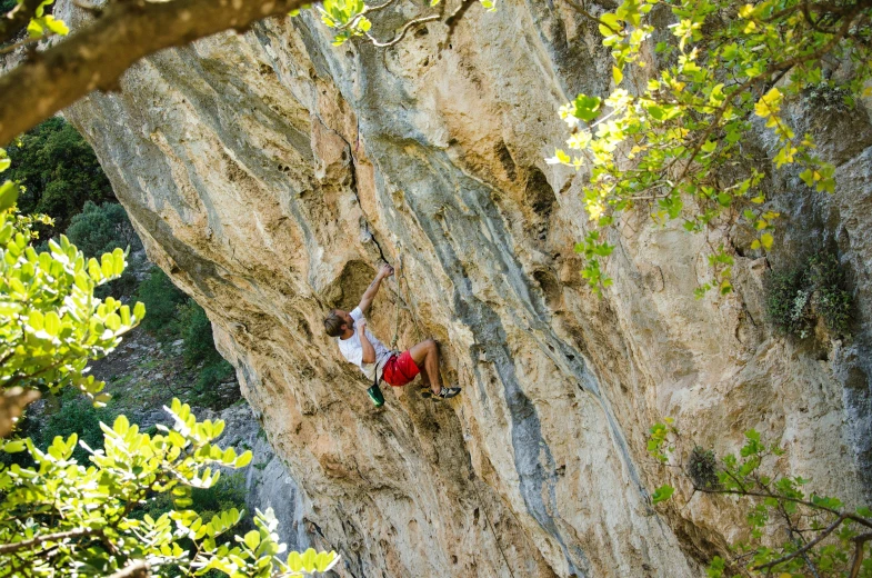 a climber is on the side of the face of a cliff