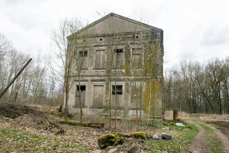 a rundown concrete building in the middle of a grassy field