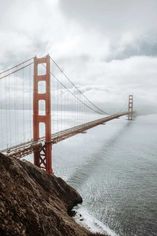 a big bridge over the ocean and some rocks