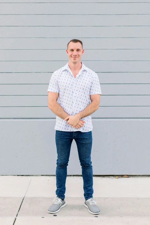 a man with his hands in the back pockets while posing for a picture