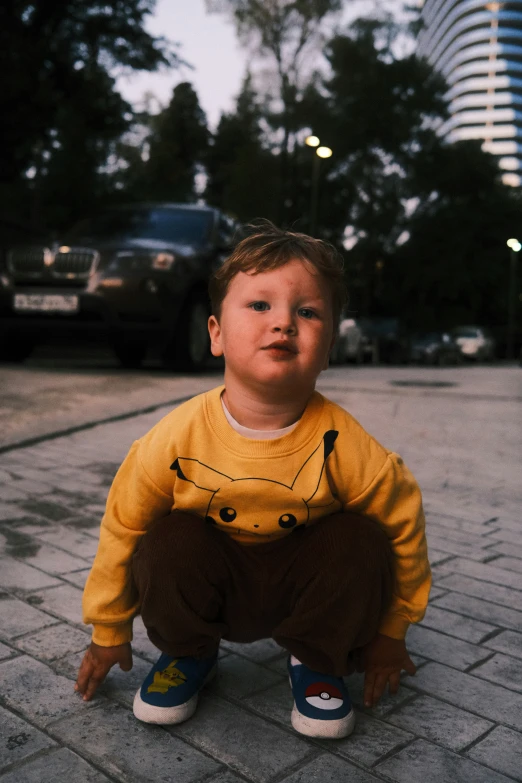 a little boy in yellow shirt with bear hat on street