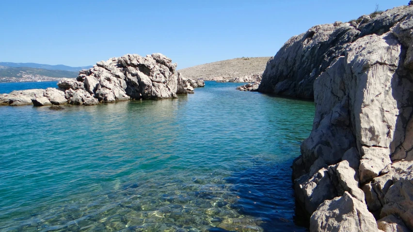 a stream going through the side of a hill next to an island